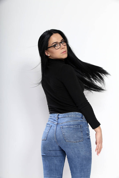 Attractive european girl with black hair and glasses posing in studio on isolated background. Style, trends, fashion concept. - Φωτογραφία, εικόνα