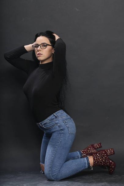 Attractive european girl with black hair and glasses posing in studio on isolated background. Style, trends, fashion concept. - Fotografie, Obrázek