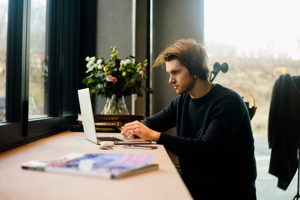 The man works in a restaurant. A guy at home sits at a computer, freelancer, student studies online - 写真・画像