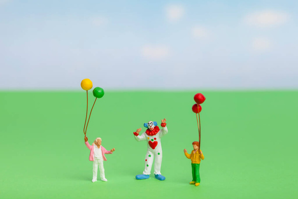 Children's holiday concept. Clown and miniature kids holding balloons - Fotó, kép
