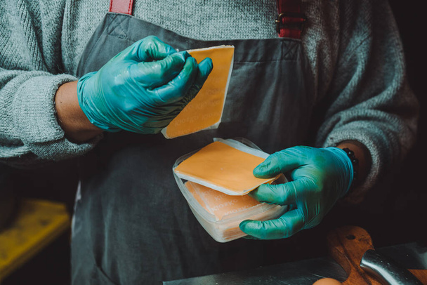 A person using cheese for making burgers - Foto, afbeelding