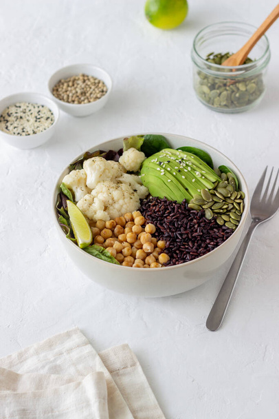 Bowl with avocado, black rice, chickpeas, cabbage, spinach and salad. Healthy eating Vegetarian food - Фото, зображення