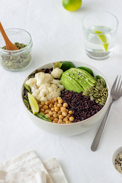 Bowl with avocado, black rice, chickpeas, cabbage, spinach and salad. Healthy eating Vegetarian food - Zdjęcie, obraz