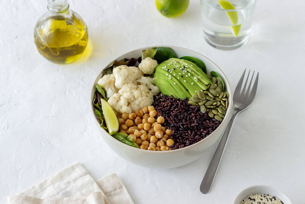 Bowl with avocado, black rice, chickpeas, cabbage, spinach and salad. Healthy eating Vegetarian food - Photo, Image