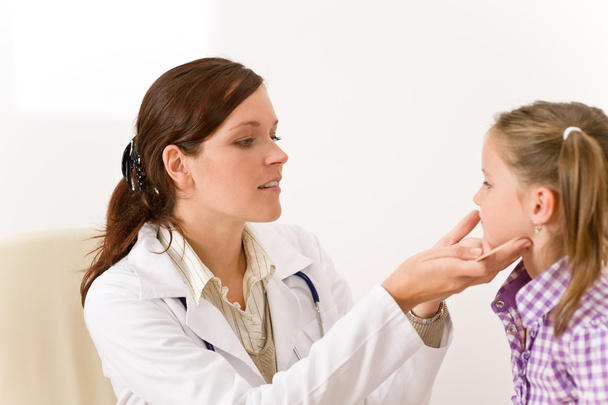 Female doctor examining child with sore throat - Foto, afbeelding