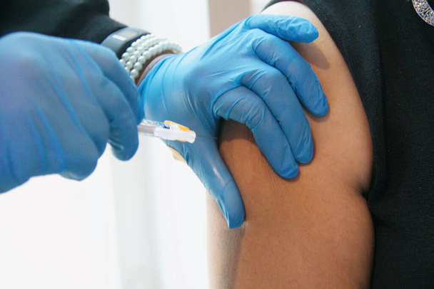 A shallow focus shot of a female getting vaccinated - Photo, image