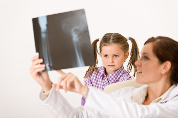 Young female doctor show x-ray to child at medical office - Photo, Image