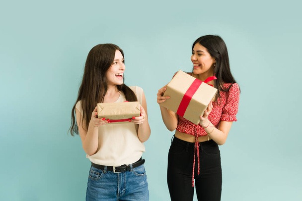 Look what I got you! Attractive besties surprising each other with beautiful gifts and feeling excited  - Photo, image
