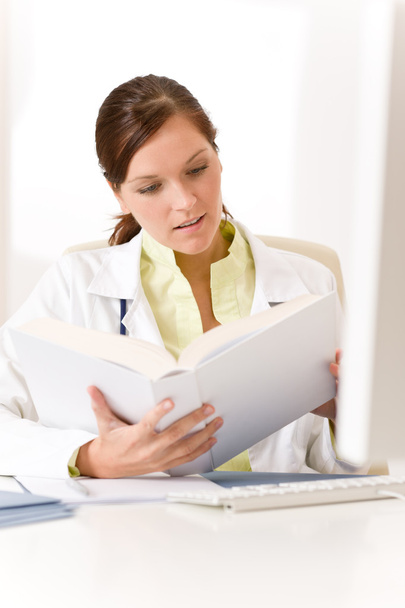 Female doctor read book in clinic - Φωτογραφία, εικόνα