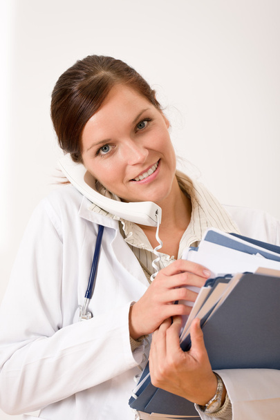 Female doctor on the phone with medical file - Foto, imagen