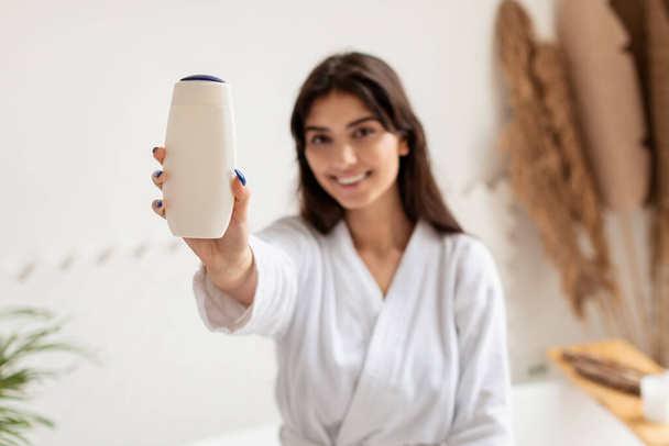 Lady zeigt Duschgelflasche Werbung Kosmetik Produkt im Badezimmer - Foto, Bild