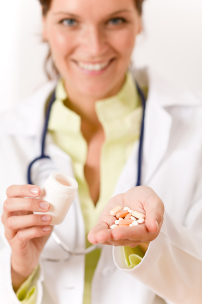 Женщина-врач со стетоскопом с таблетками и пузырьком с лекарствами
 - Фото, изображение