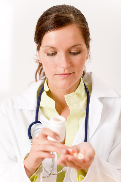 Female doctor with stethoscope holding tablet and medicine bottle - Foto, Imagen