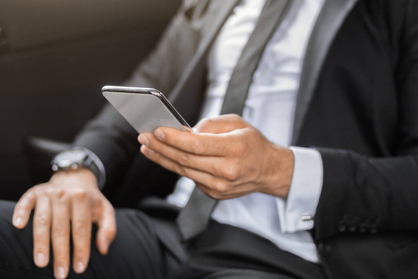 Unrecognizable businessman using mobile app on smartphone - Fotó, kép