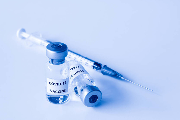 Beyaz arka planda izole edilmiş Covid-19 aşısı şişesi ve 1 ml plastik şırınga. - Fotoğraf, Görsel