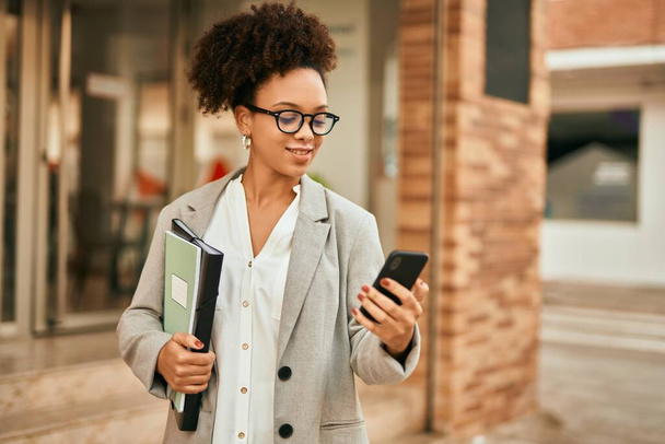 Young african american businesswoman smiling happy using smartphone at the city. - Foto, Bild