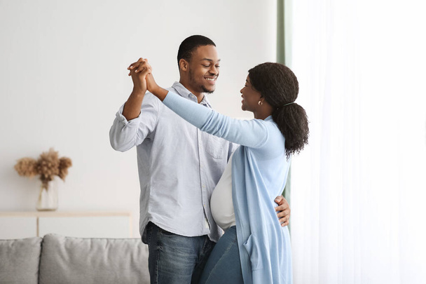 ロマンチックな黒妊娠中のカップルダンス-ホーム - 写真・画像