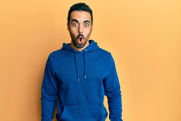 Young hispanic man wearing casual clothes afraid and shocked with surprise expression, fear and excited face.  - Foto, Imagen
