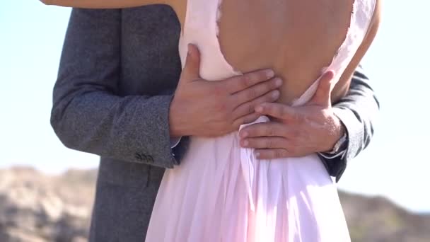El novio abraza a la novia y suavemente acaricia su espalda abierta, de cerca - Imágenes, Vídeo