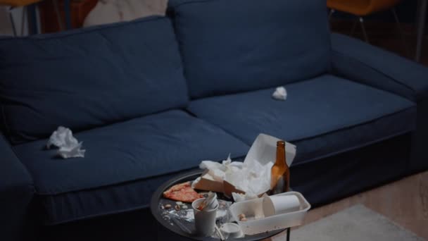 Закрыть грязный стол с остатками еды в пустой неорганизованной гостиной - Кадры, видео