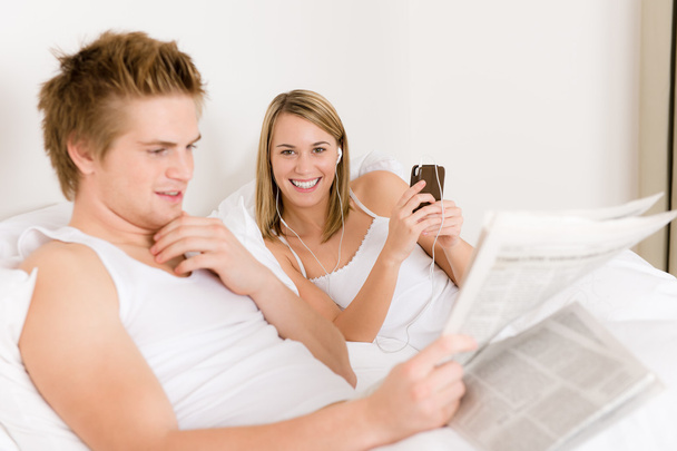 Young couple relax in bed listen to music - Foto, Imagen