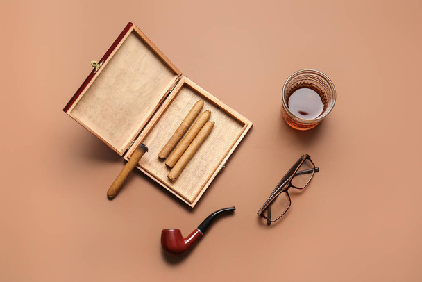 Composition with glass of whiskey and cigars on color background - Photo, Image