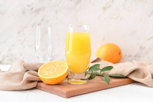 Стекло с апельсиновым соком на светлом фоне - Фото, изображение