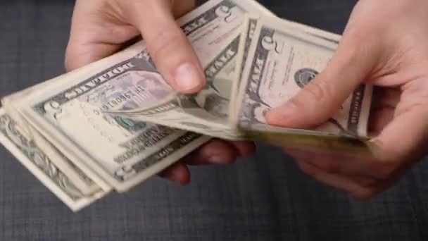 Naisten kädet laskevat Yhdysvaltain dollarin seteleitä hänen käsissään. Näkymä ylhäältä. 4k-video - Materiaali, video