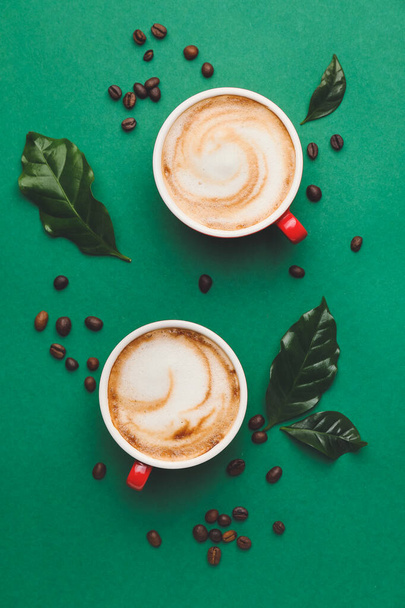 Bekers van hete cappuccino op kleur achtergrond - Foto, afbeelding