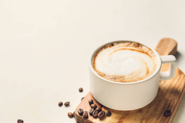 Cup of hot cappuccino on light background - Φωτογραφία, εικόνα