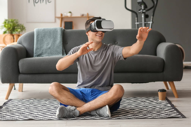 Young man with virtual reality glasses at home - Valokuva, kuva