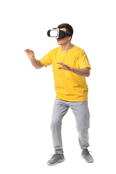 Fiatal férfi virtuális valóság szemüveg fehér háttér - Fotó, kép