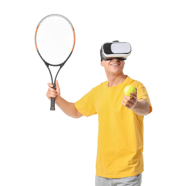 Sporty young man with virtual reality glasses playing tennis on white background - Photo, Image