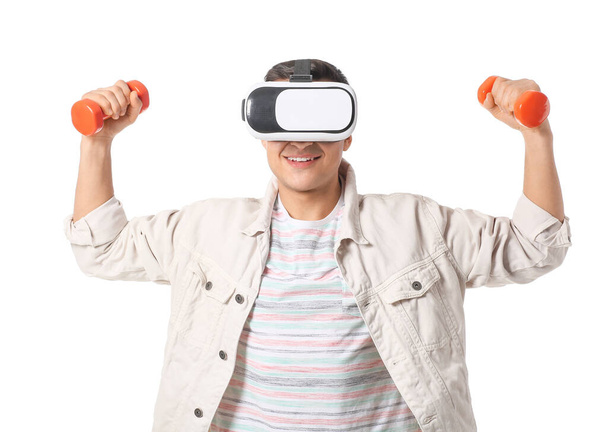 Sporty young man with virtual reality glasses and dumbbells on white background - Valokuva, kuva