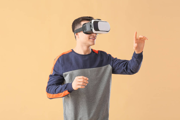 Fiatal férfi virtuális valóság szemüveg színes háttér - Fotó, kép