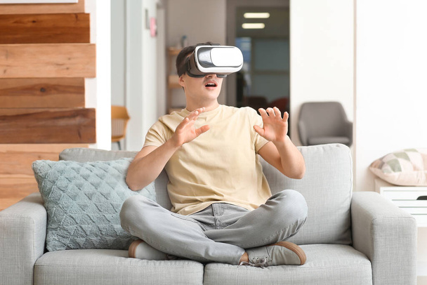 Young man with virtual reality glasses at home - Фото, изображение