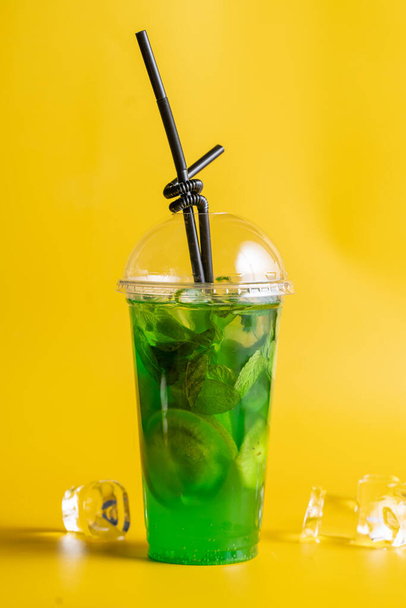 No alcoholic cocktails in a plastic glass on a yellow background - Zdjęcie, obraz