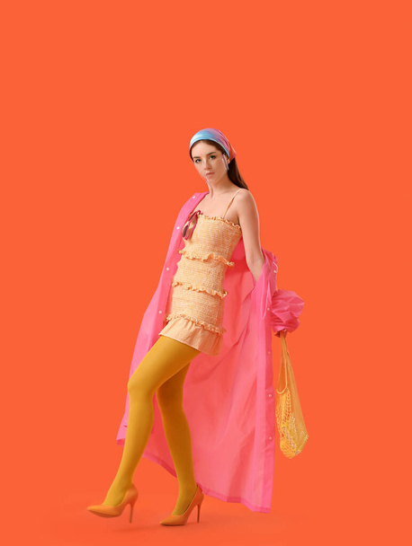 Mujer joven de moda con máscara en el fondo de color - Foto, Imagen