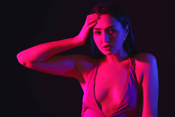Toned portrait of beautiful young woman on dark background - Fotó, kép