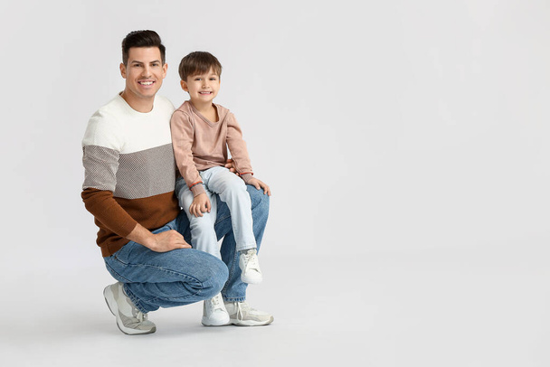 Happy father and his little son on light background - Photo, image