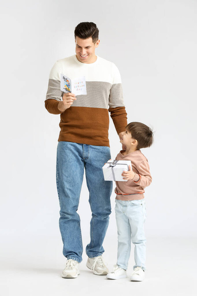 Little boy greeting his dad on Father's Day against light background - Photo, Image