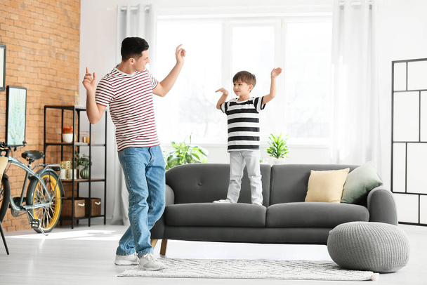 Glücklicher Vater und sein kleiner Sohn tanzen zu Hause - Foto, Bild