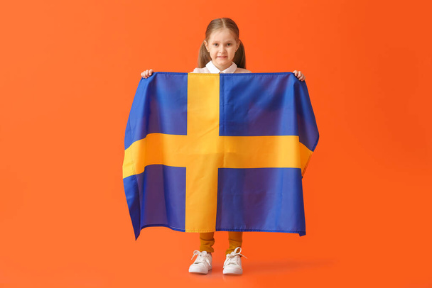 Little girl with the flag of Sweden on color background - Φωτογραφία, εικόνα