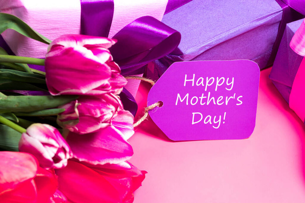 Herkkä vaaleanpunainen tulppaanit ja lahjapakkaukset tag kirjoitus Hyvää äitienpäivää - Valokuva, kuva