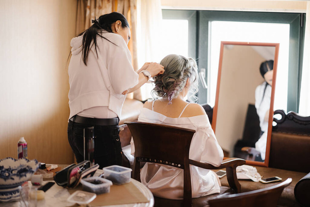 Estilista faz a noiva na frente do espelho um penteado bonito complexo - Foto, Imagem