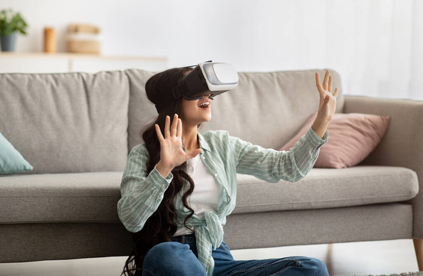 Millennial donna indiana in occhiali realtà virtuale esplorare il cyberspazio, giocare video gioco interattivo al chiuso - Foto, immagini