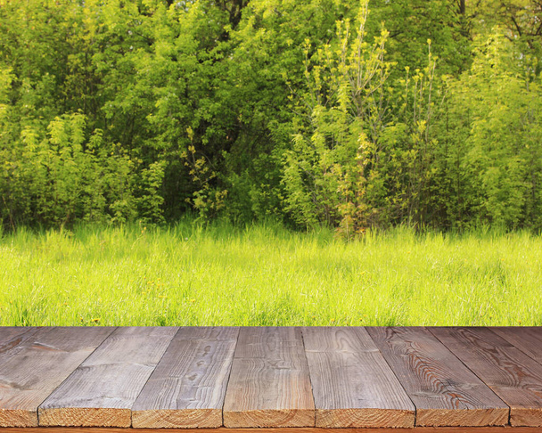 empty wooden table on a green spring background. space for your object, mockup, layout. - Foto, imagen