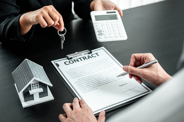 Immobilienmakler präsentieren Hauskredit und senden Schlüssel an den Kunden nach Unterzeichnung des Vertrages zur Vermietung Haus Versicherung mit genehmigtem Immobilienformular. - Foto, Bild