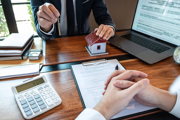 Real estate agent are presenting home loan and sending keys to customer after signing contract to buy house with approved property application form, Insurance Home concept. - 写真・画像