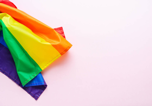 Regenboogvlag op roze achtergrond. LGBTQIA cultuur. Gay Pride Day. Kopieerruimte. - Foto, afbeelding